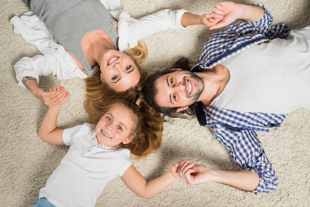 Portrait de famille vue de dessus pose sur un tapis