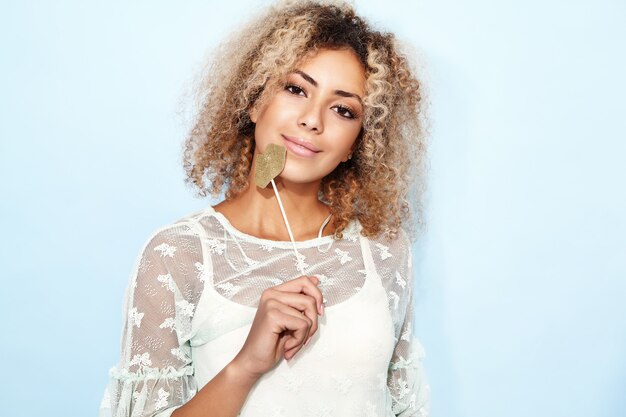 Portrait d'une femme adorable et heureuse avec une coiffure africaine blonde avec de grosses lèvres sur un bâton.