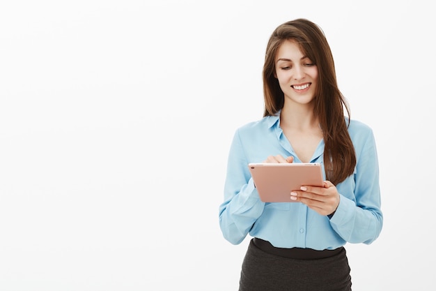 Portrait de femme d'affaires brune heureuse posant dans le studio