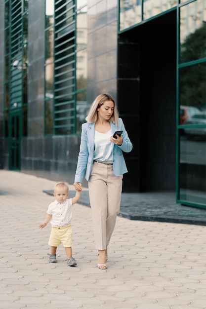 Portrait d'une femme d'affaires réussie en costume bleu avec bébé