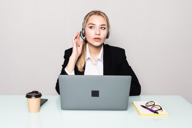 Portrait d'une femme d'affaires souriant avec un casque sur le travail dans un centre d'appels au bureau