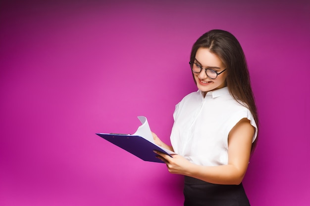 Portrait de femme d'affaires souriante avec dossier papier, isolé sur violet.