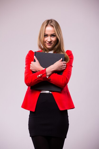 Portrait de femme d'affaires souriante avec dossier rouge, isolé sur mur blanc