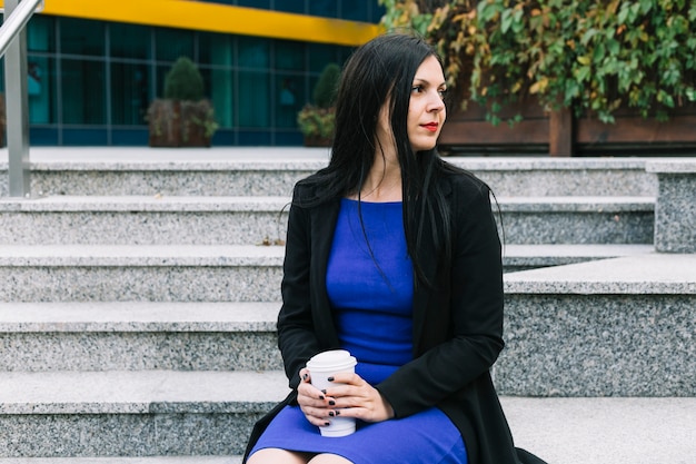 Portrait d&#39;une femme d&#39;affaires avec une tasse de récupération à la recherche de suite