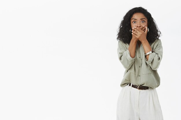 Portrait de femme afro-américaine inquiète choquée et sans voix aux cheveux bouclés