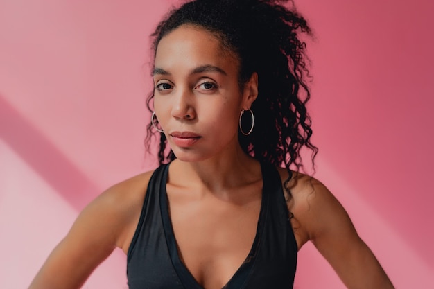 Portrait De Femme Afro-américaine Noire En Tenue De Fitness Haut Noir Sur Rose