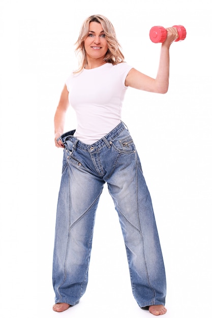 Photo gratuite portrait de femme âgée heureuse portant de gros jeans et haltères