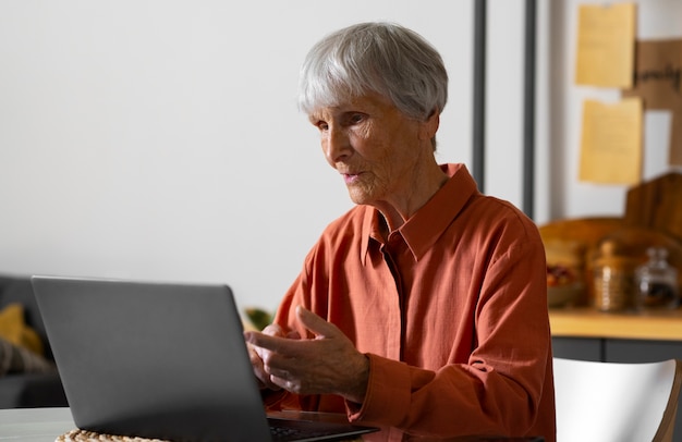 Portrait d'une femme âgée utilisant un ordinateur portable à la maison