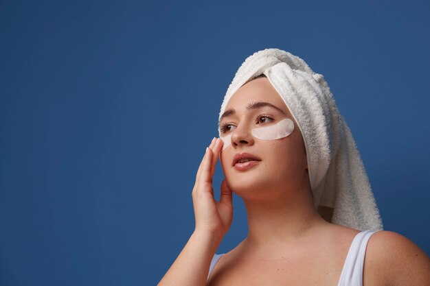 Portrait de femme à l'aide de pansements oculaires pour la beauté