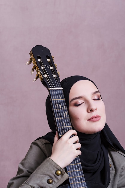 Photo gratuite portrait de femme arabe à la guitare