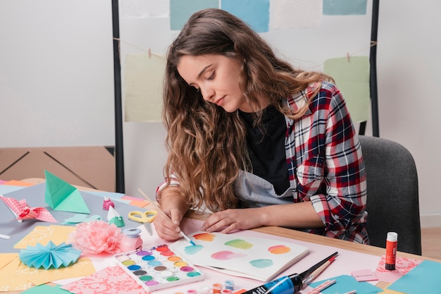 Portrait de femme artiste peignant sur du papier blanc