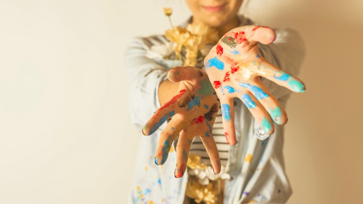 Photo gratuit portrait de femme artiste avec de la peinture sur les mains