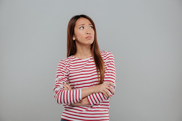 Portrait d'une femme asiatique déprimée debout avec les bras croisés