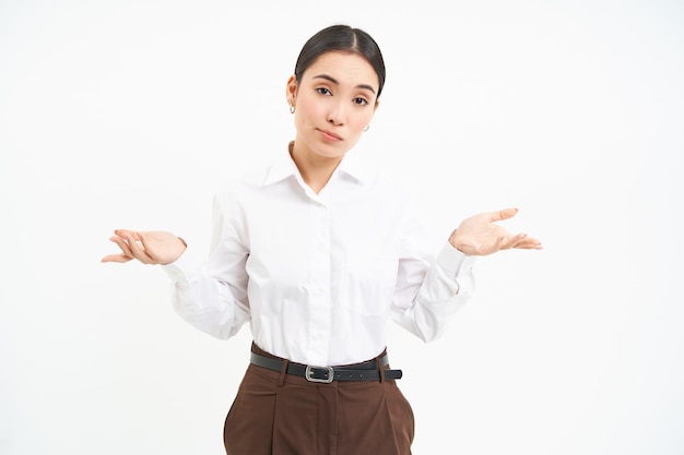 Photo gratuite portrait de femme asiatique hausse les épaules semble confus et désemparé se dresse sur la zone de studio blanc