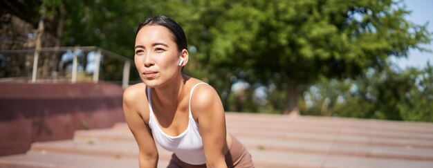 Photo gratuite portrait d'une femme asiatique prenant une pause respirant lourdement et haletant après avoir couru jogger debout et