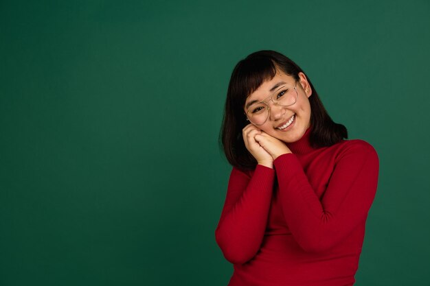 Portrait de femme d'Asie de l'Est isolé sur fond de studio vert avec espace pour copie