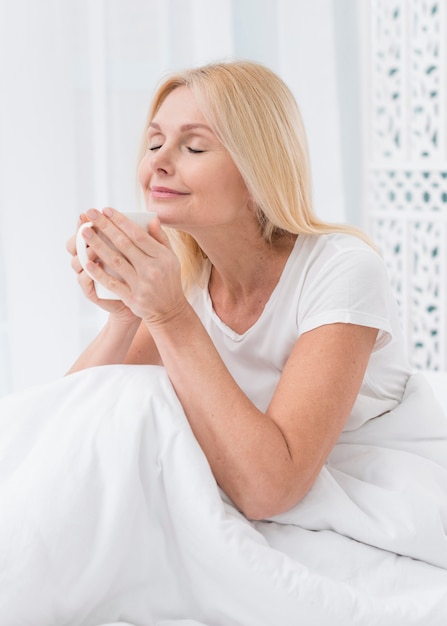 Portrait de femme assez âgée appréciant le café