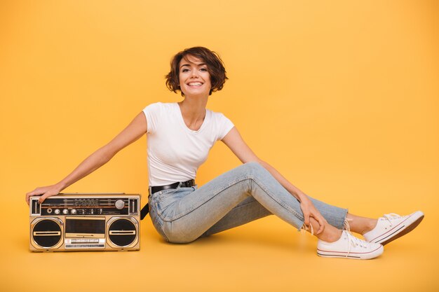 Portrait d'une femme assez joyeuse assise avec tourne-disque