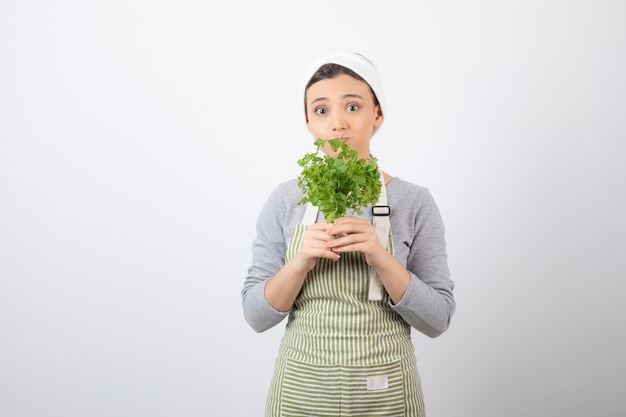 Portrait d'une femme assez mignonne tenant un faisceau de persil frais