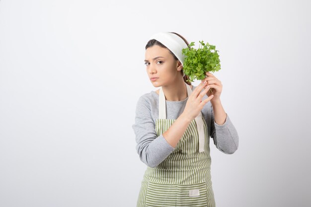 Portrait d'une femme assez mignonne tenant un faisceau de persil frais