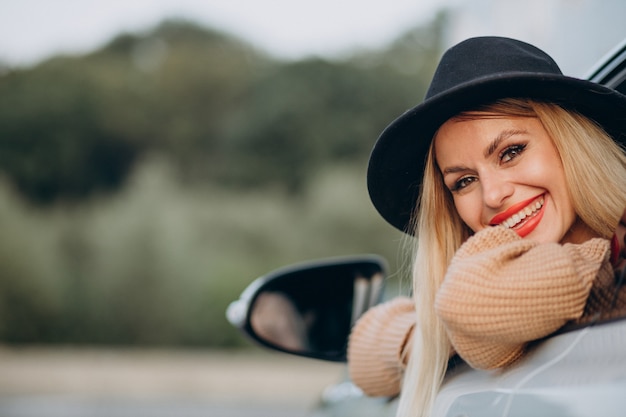 Portrait de femme assise dans la voiture et regardant par la fenêtre