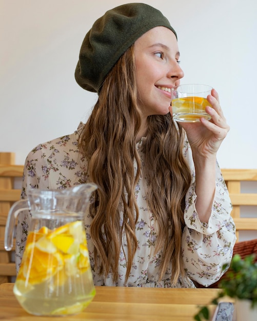 Portrait de femme assise à table avec de la limonade