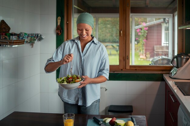 Portrait d'une femme atteinte de cancer mangeant une salade à la maison