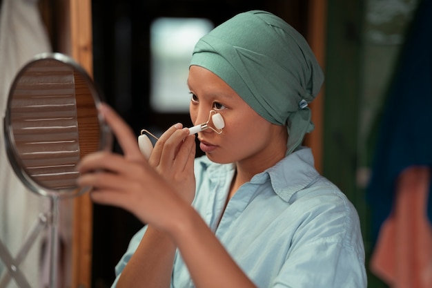 Portrait d'une femme atteinte de cancer qui s'occupe de sa peau à la maison