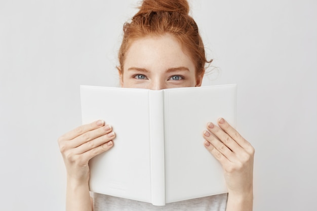 Portrait De Femme Au Gingembre Se Cachant Derrière Le Livre.