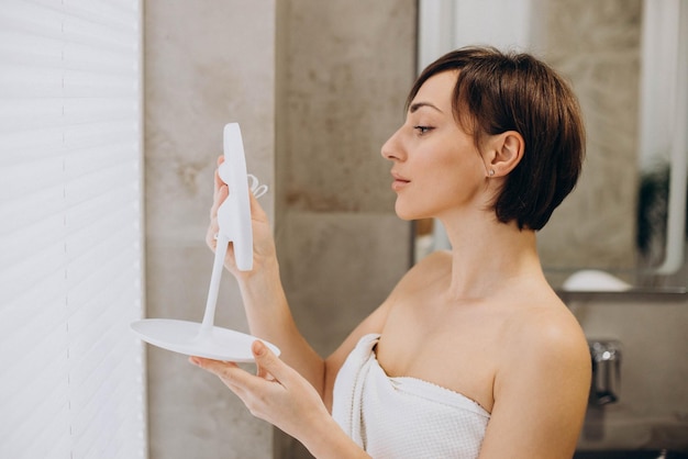 Portrait de femme au spa regardant dans le miroir