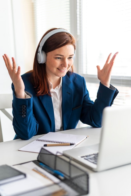 Portrait femme au travail ayant appel vidéo