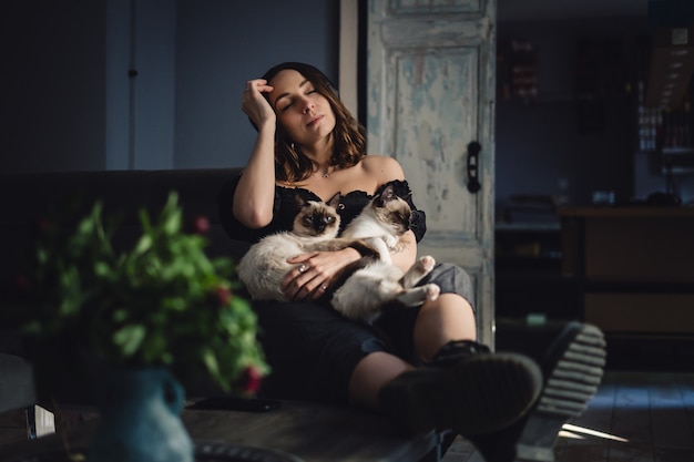 Portrait femme aux chats siamois