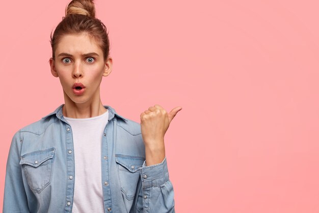 Portrait de femme aux cheveux en chignon et portant une chemise en jean