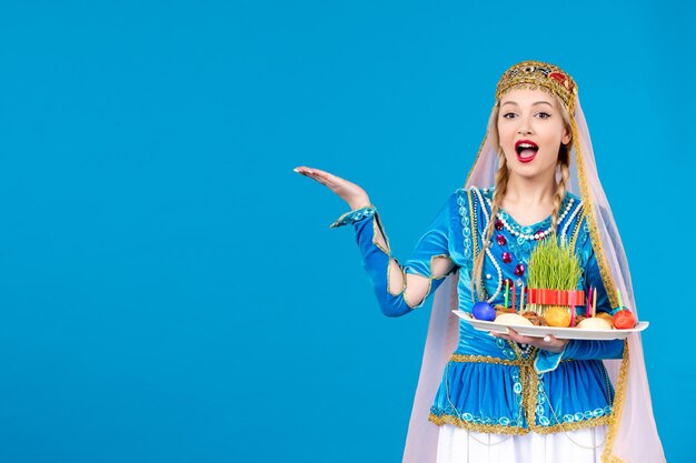 Portrait de femme azérie en costume traditionnel avec novruz xonca studio tourné fond bleu concept ethnique danseurs de printemps