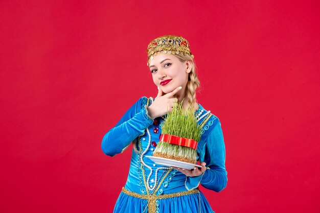Portrait de femme azérie en costume traditionnel avec semeni studio shot fond rouge concept maison de vacances printemps ethnique