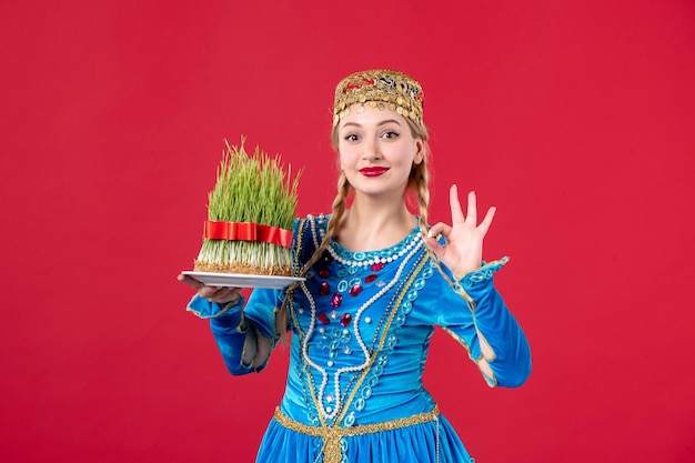 Photo gratuite portrait de femme azérie en costume traditionnel avec semeni studio shot fond rouge concept printemps danseurs novruz