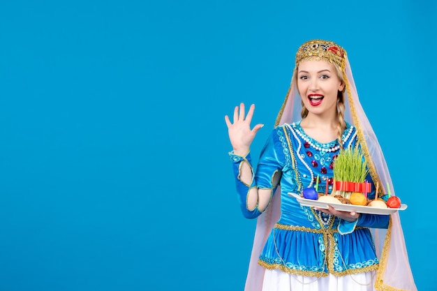 Portrait de femme azérie en costume traditionnel avec xonca excité sur fond bleu danseuse de printemps ethnique novruz