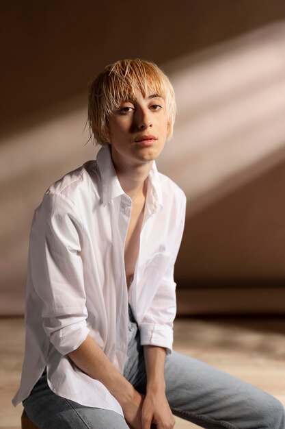 Portrait de femme blonde aux cheveux courts posant dans une chemise blanche