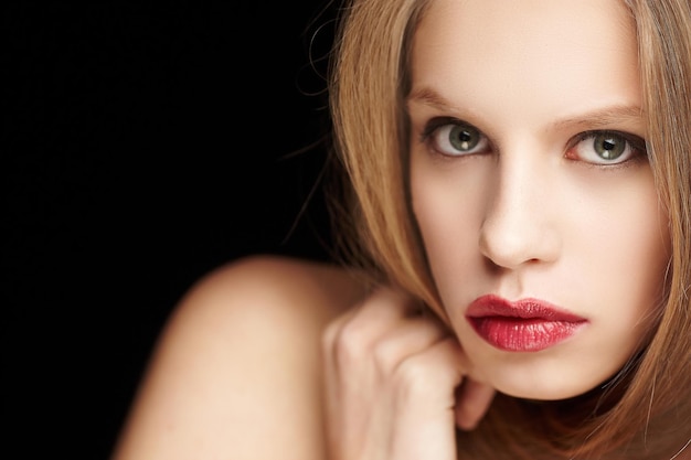 Portrait de femme blonde aux lèvres rouges isolé sur fond noir.