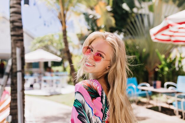 Portrait de femme blonde enthousiaste posant avec un sourire heureux sincère.