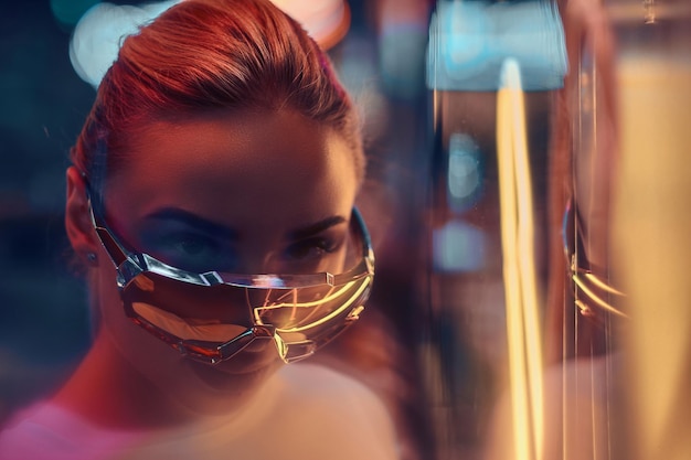 Photo gratuite portrait d'une femme branchée pensive en lunettes de soleil et t-shirt blanc avec néons roses.