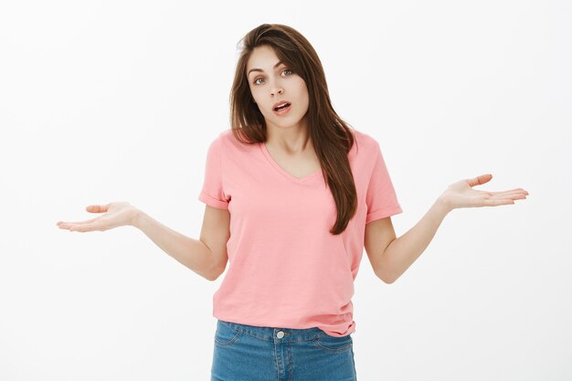 Portrait de femme brune désemparée inconsciente qui pose en studio