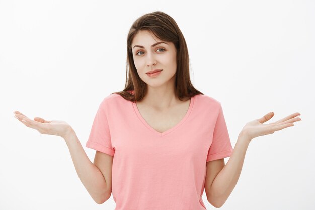 Portrait de femme brune désemparée inconsciente qui pose en studio