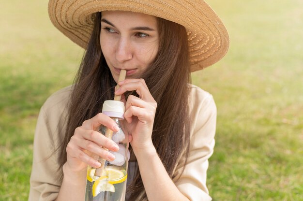 Portrait de femme buvant de l'eau avec des citrons