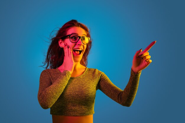 Portrait de femme caucasienne isolé sur fond bleu studio en néon