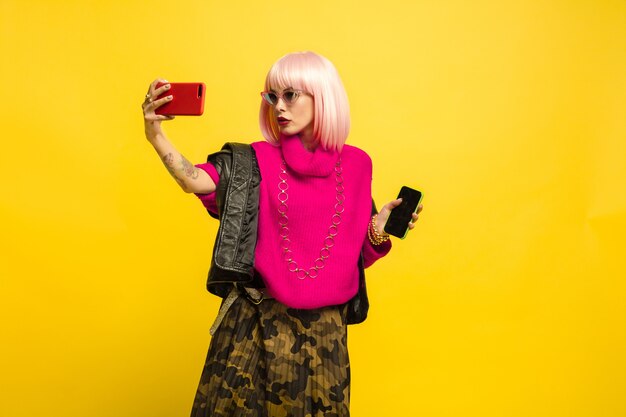 Portrait de femme caucasienne isolé sur fond de studio jaune, influenceur être comme