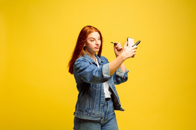 Portrait de femme caucasienne isolé sur fond de studio jaune, suiveur être comme