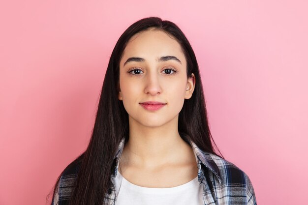 Portrait de femme caucasienne isolé sur fond de studio rose corail avec fond