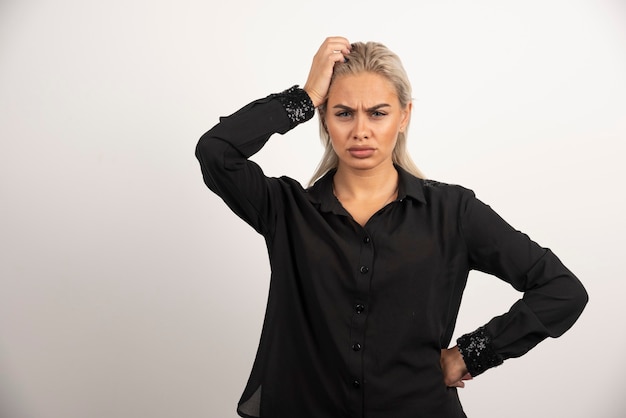 Portrait de femme en chemise noire posant sur fond blanc. Photo de haute qualité