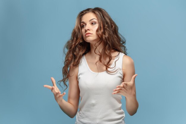 Portrait d'une femme en colère à l'écart sur un fond bleu